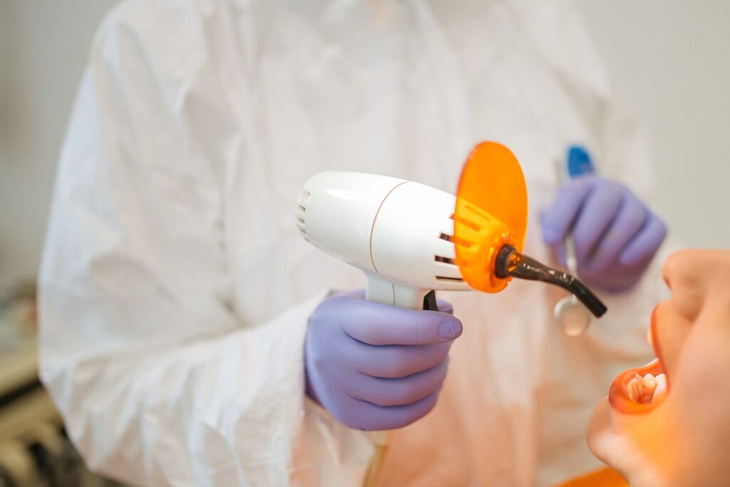 A dentist using a curing light during a routine check-up