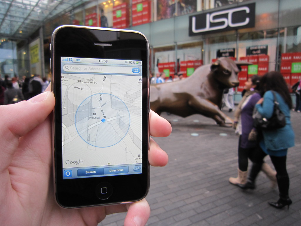 A hand holding a phone showing a street map in a city centre