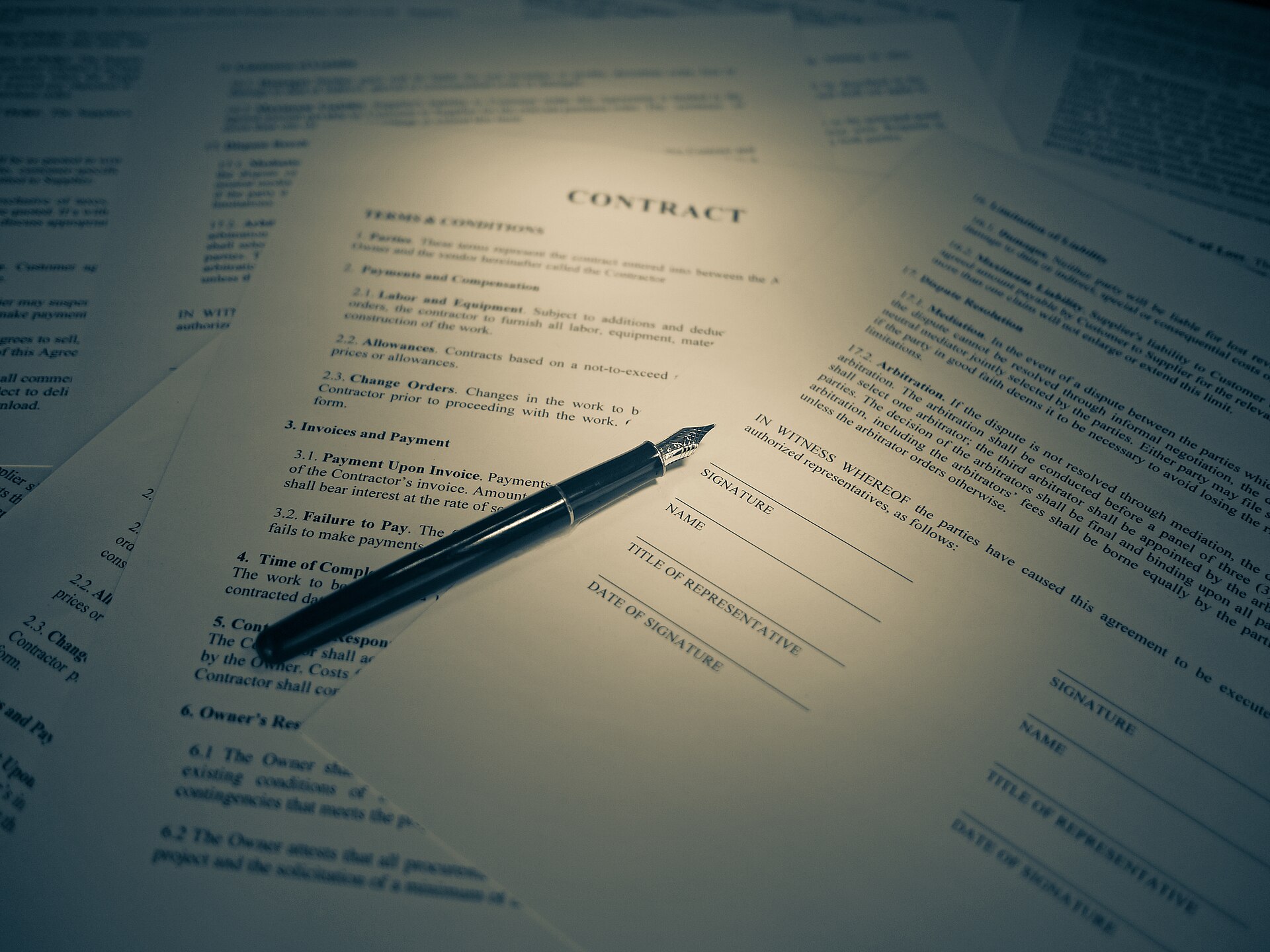 A printed contract with a fountain pen resting on the signature page