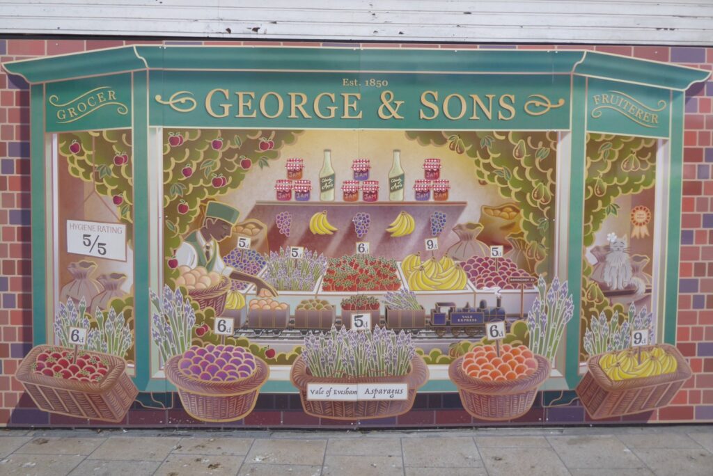 A hand painted grocer shop front sign on a high street